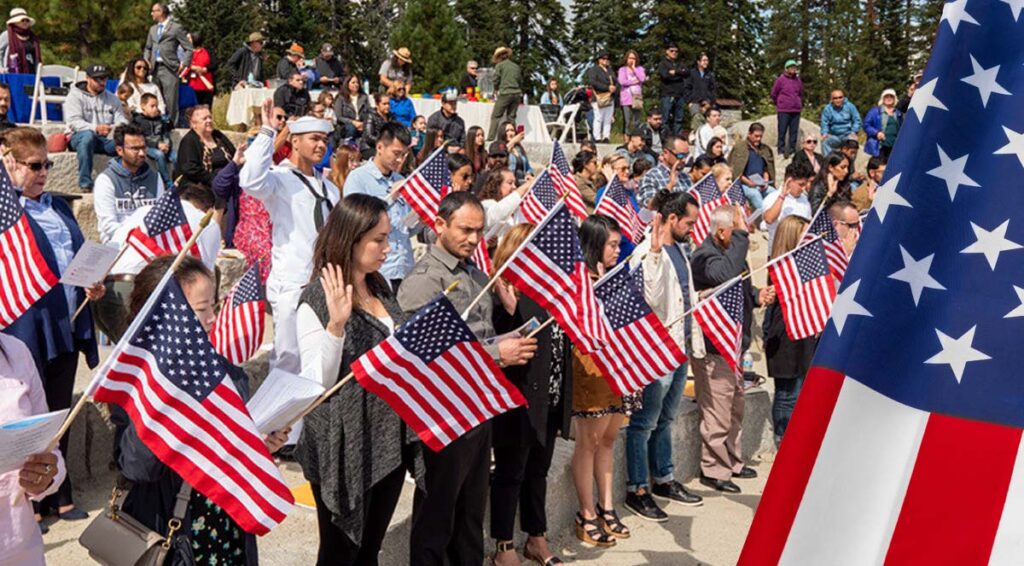 Ceremonia de naturalización en EE.UU. con migrantes jurando lealtad durante su proceso de ciudadanía